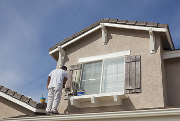 Image showing House Painter Painting the Trim And Shutters of Home