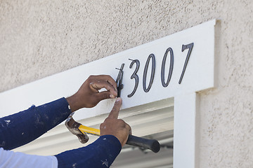 Image showing House Painter Contractor Nails Address Numbers to House Facade