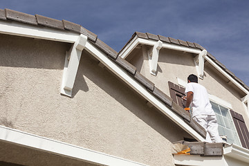 Image showing House Painter Painting the Trim And Shutters of Home