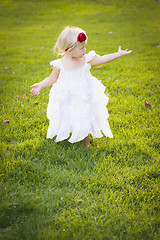 Image showing Adorable Little Girl Wearing White Dress In A Grass Field