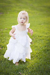 Image showing Adorable Little Girl Wearing White Dress In A Grass Field