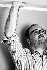 Image showing man in striped shirt touching ceiling with hand