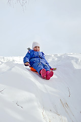 Image showing Little girl rolling on a hill
