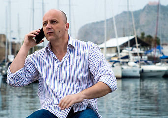 Image showing businessman talking on the phone close to the luxurious harbor