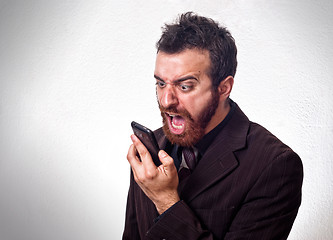 Image showing Man in business suit shouting into his mobile phone