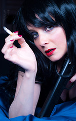 Image showing Beautiful brunette girl with cigarette and gun