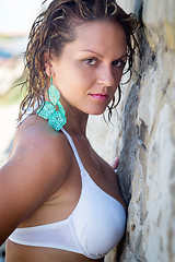 Image showing Beautiful girl in bikini  stands near the stone wall