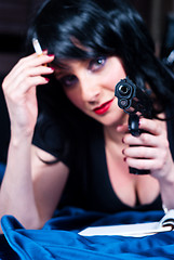 Image showing Beautiful brunette girl with cigarette and gun