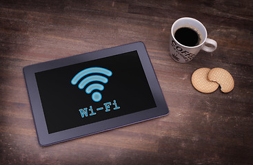 Image showing Tablet with Wi-Fi connection on a wooden desk