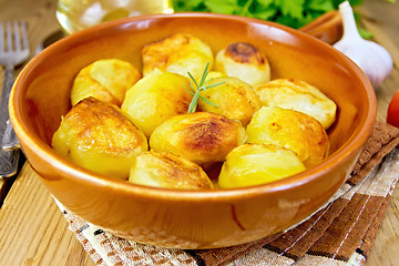 Image showing Potatoes fried in ceramic pan on napkin
