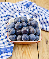 Image showing Plum blue in bowl on board with napkin