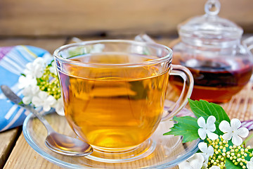 Image showing Tea from flowers of viburnum on wooden board with napkin