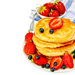 Image showing Flapjacks with strawberries and blueberries in bowl with napkin