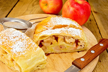 Image showing Strudel apple with strainer and knife on board