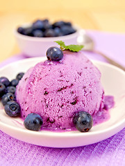 Image showing Ice cream blueberry in bowl on purple napkin