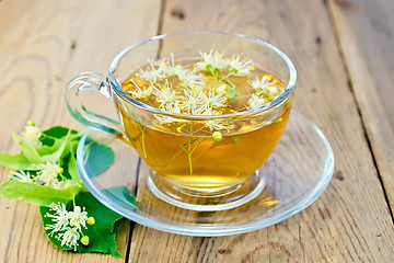 Image showing Herbal tea of linden flowers in glass cup on board