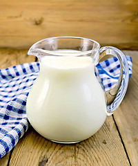 Image showing Milk in glass jug with napkin on board