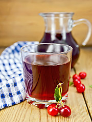 Image showing Compote cherry in glass jug on board