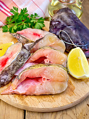 Image showing Catfish raw with lemon on board