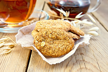 Image showing Cookies oatmeal with spikelet and tea on board