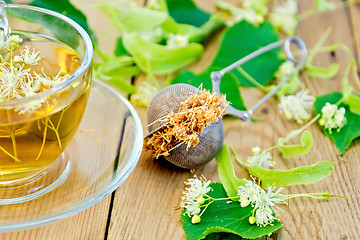 Image showing Herbal tea of linden flowers in strainer with cup