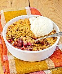 Image showing Crumble cherry in bowl with ice cream on board