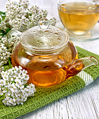 Image showing Tea with yarrow in glass teapot on board