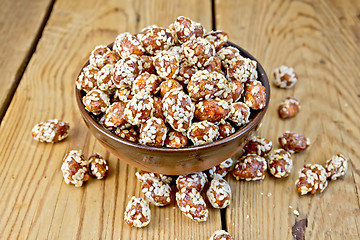 Image showing Peanuts in caramel with sesame on wooden board