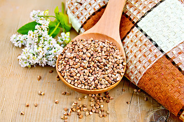 Image showing Buckwheat in wooden spoon with flower and doily