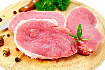 Image showing Meat pork slices with rosemary on round board
