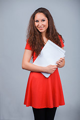 Image showing Young attractive girl in red with folders