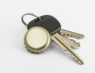 Image showing car key and bottle cap in close up