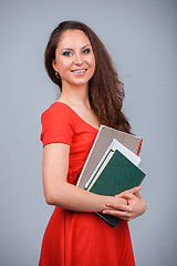 Image showing Young attractive girl in red with folders