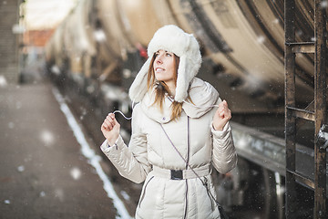 Image showing Pretty girl in winter blizzard on railroad station
