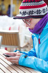 Image showing Woman in ski resort using smartphone.