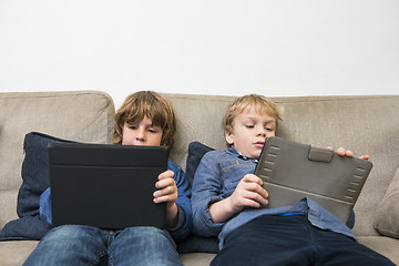 Image showing Boys Using Digital Tablets On Sofa