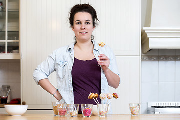 Image showing Woman Holding Cupcake Pop In Kitchen