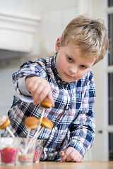 Image showing Boy putting cupcake pop in glass