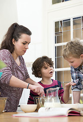 Image showing Family Preparing Cupcake Batter In Kitchen