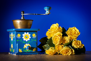 Image showing Blue coffee grinder and roses