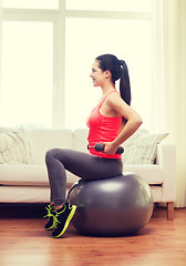 Image showing smiling girl exercising with fitness ball