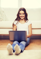 Image showing smiling teenage girl with laptop computer at home