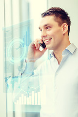 Image showing smiling businessman with smartphone in office