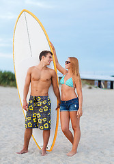 Image showing smiling couple in sunglasses with surfs on beach