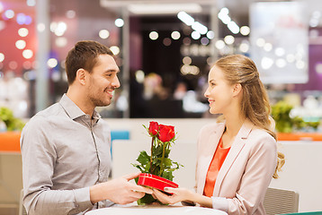 Image showing happy couple with present and flowers in mall