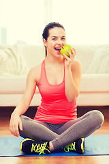 Image showing smiling teenage girl with green apple at home