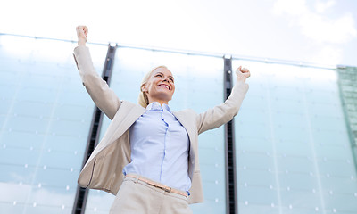 Image showing young smiling businesswoman over office building