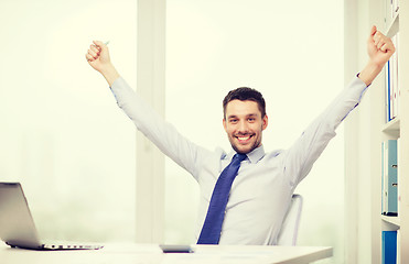 Image showing smiling businessman with laptop and documents