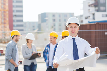 Image showing group of builders with tablet pc and blueprint