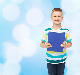 Image showing smiling little student boy with blue book